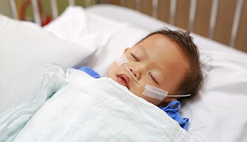 infant lying in hospital bed with oxygen