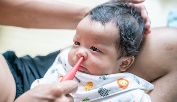 infant getting its nose suctioned