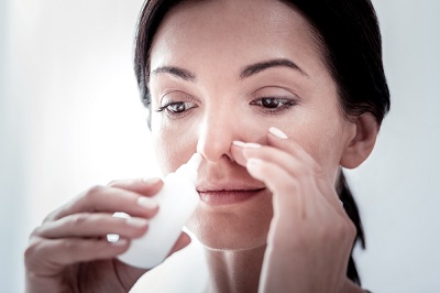 woman using a nose spray