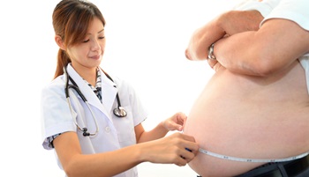 doctor measureing obese abdomen