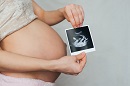 pregnant woman holding ultrasound image