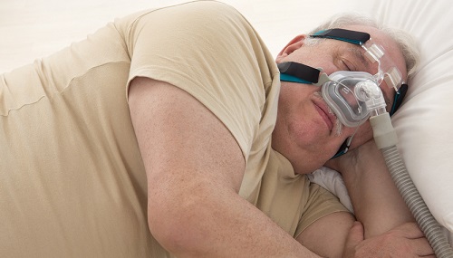 man wearing CPAP while sleeping